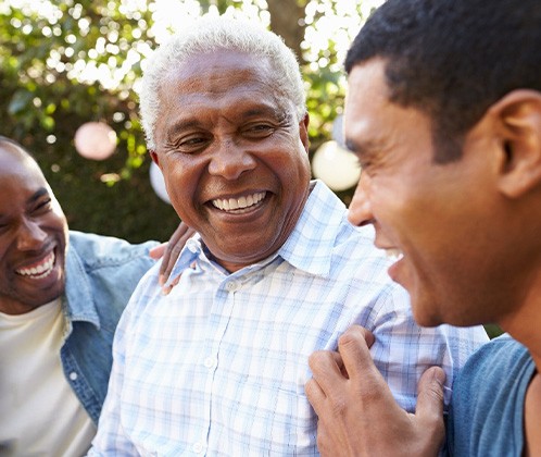 3 men outside talking and smiling together