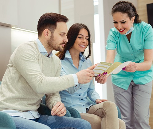 Patient weighing teeth whitening treatment options with dental team