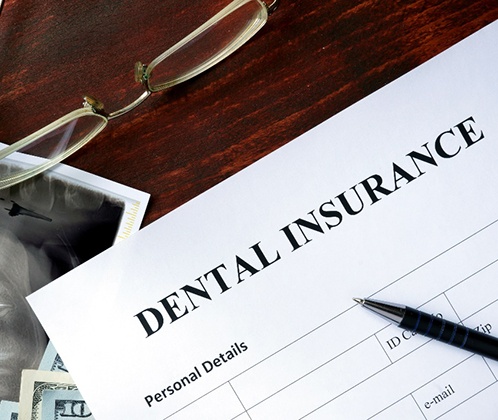 A dental insurance form sitting on a wooden table