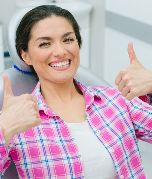 Happy dental patient giving two thumbs up