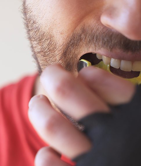 Patient in Lakewood wearing a mouthguard to avoid dental emergencies