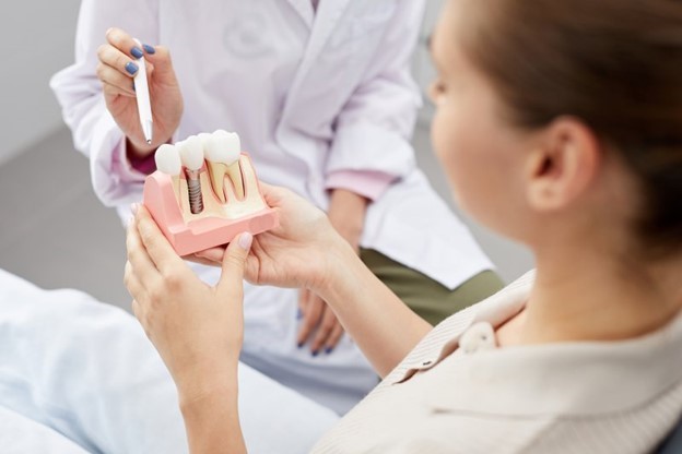 patient holding dental implant model