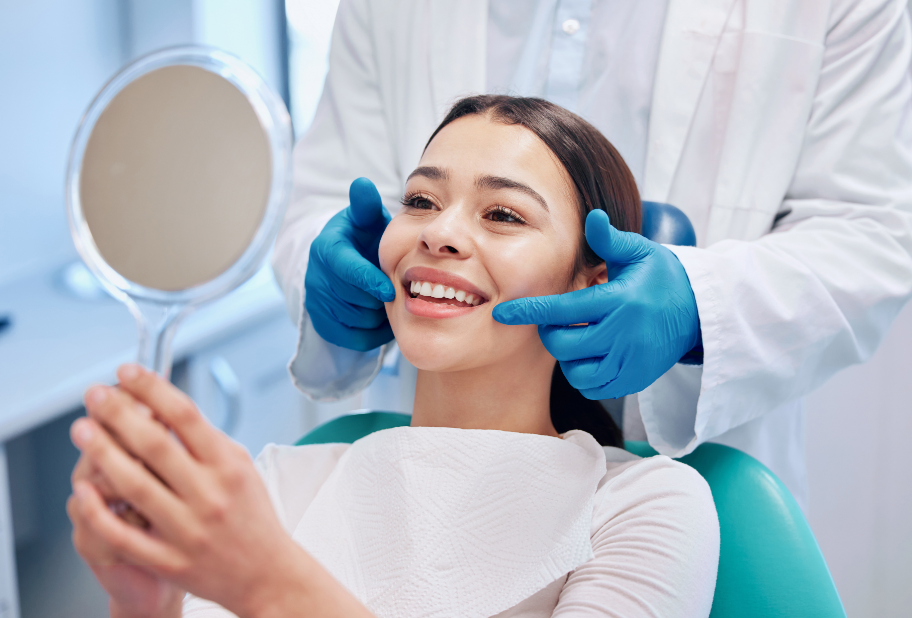Woman smiling at mirror in dental chair