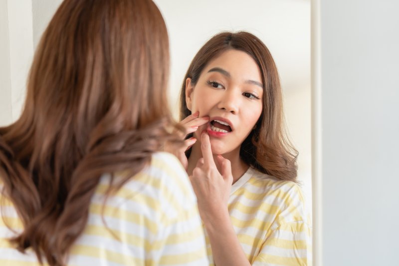 Patient checking mouth for gum disease in mirror